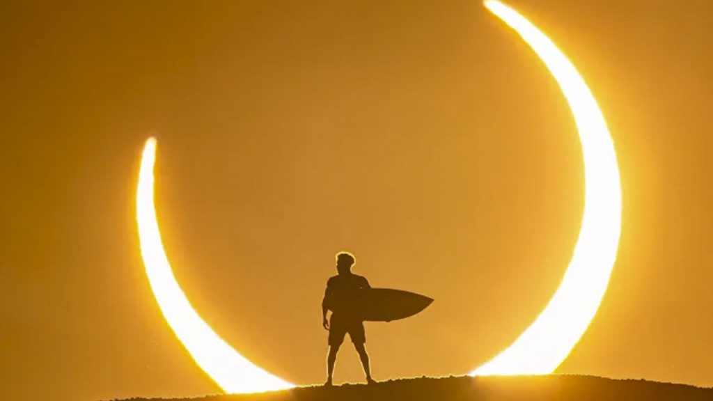 O surfista Ítalo Ferreira, em uma das fotos mais impressionantes do último eclipse solar